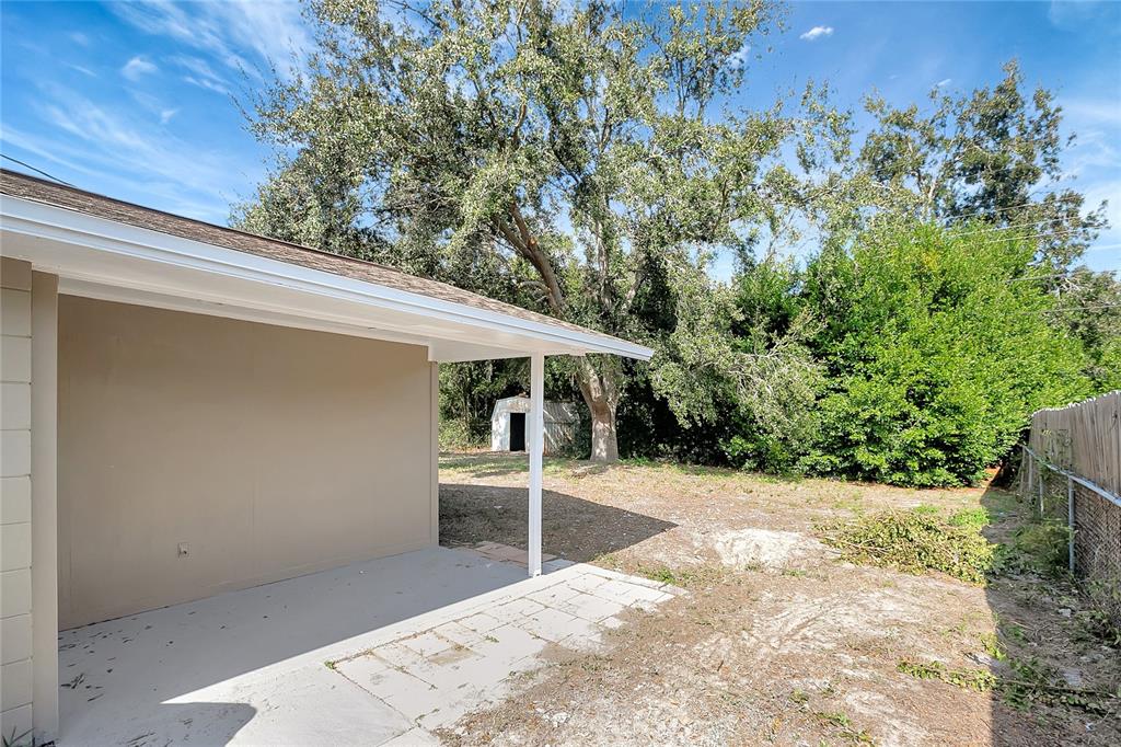 5605 Oceanic Road Holiday, FL 34690 - Photo 33 of 36 a view of a patio with table and chairs with wooden fence and plants