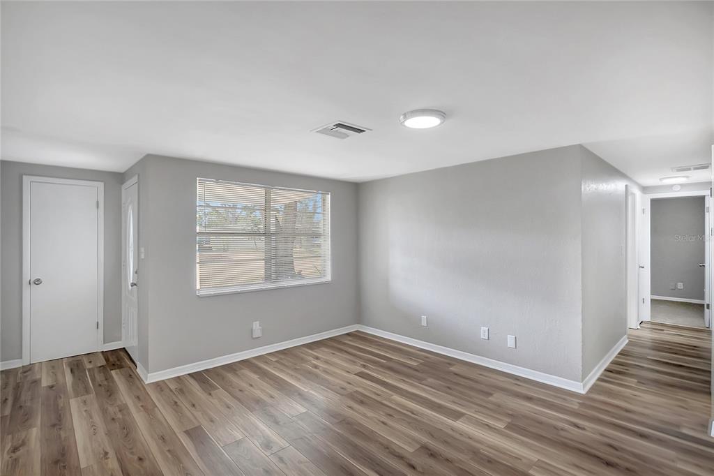 5605 Oceanic Road Holiday, FL 34690 - Photo 7 of 36 a view of an empty room with wooden floor and a window