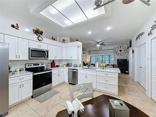 a kitchen with stainless steel appliances a stove a sink cabinets and a dining table