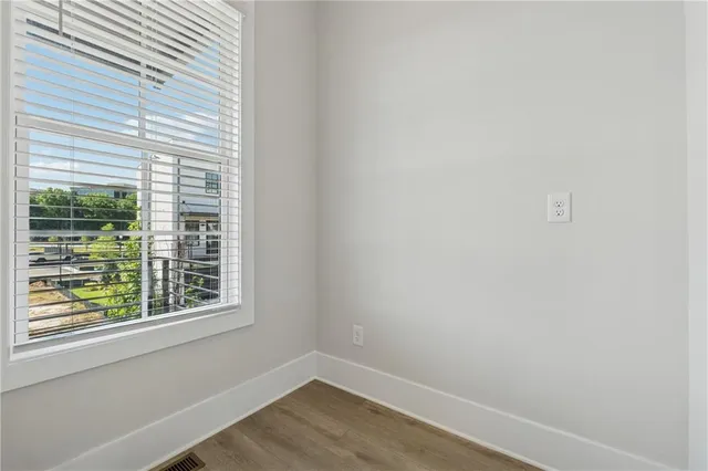 a view of a small space with wooden floor and a window