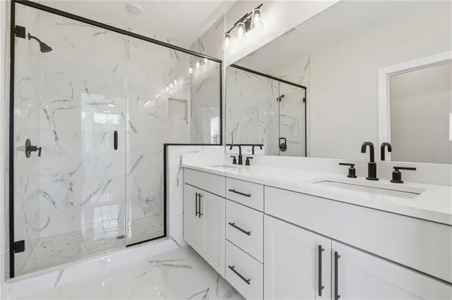 a bathroom with a double vanity sink mirror and shower
