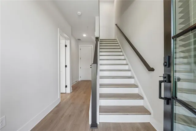 a view of staircase with wooden floor and white walls