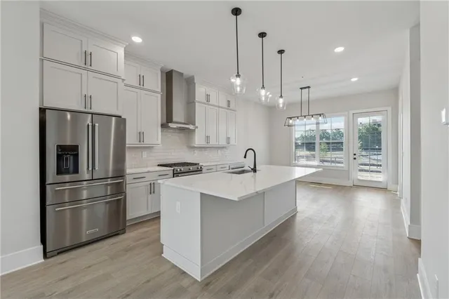 a kitchen with kitchen island white cabinets and stainless steel appliances