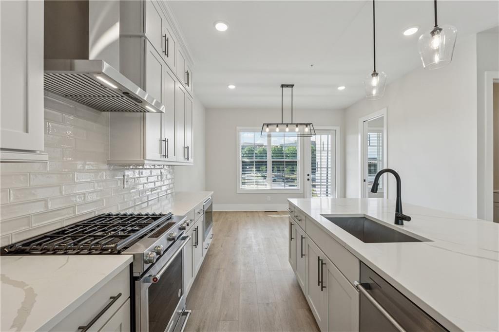 428 Mezzo Lane Alpharetta, GA 30009 - Photo 7 of 30 a kitchen with stainless steel appliances granite countertop a sink a stove and a wooden floors