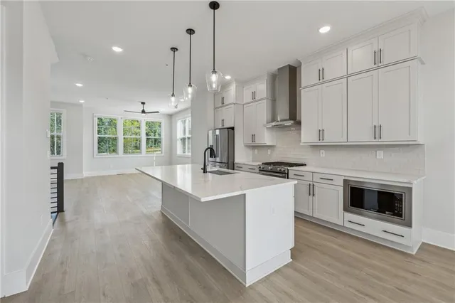 a large kitchen with stainless steel appliances granite countertop a stove a sink and a refrigerator