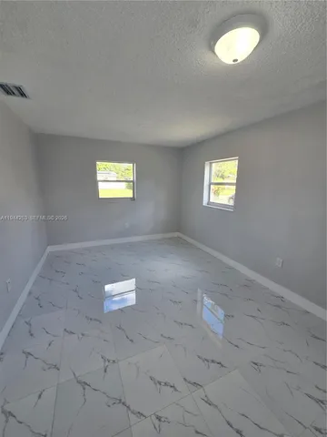 a view of a house with a yard and a large tree
