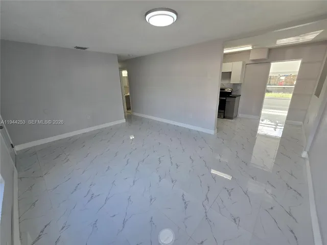 a kitchen with granite countertop a sink a stove and a refrigerator