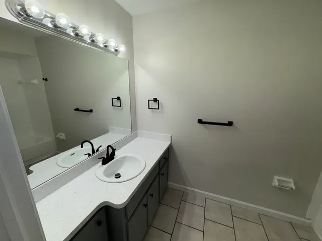 a bathroom with a granite countertop sink a toilet and shower