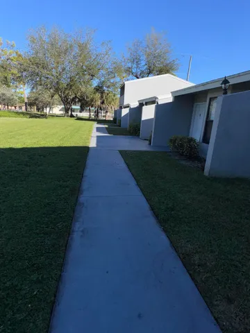 a view of a fountain in front of a house with a big yard