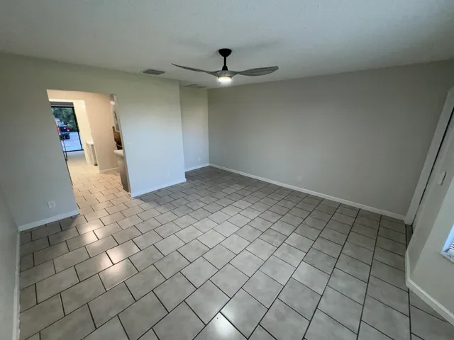 an empty room with windows and ceiling fan