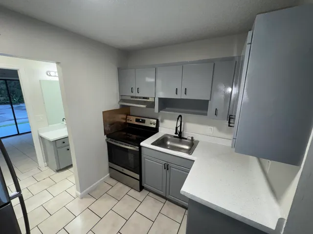 a kitchen with a sink stove and cabinets