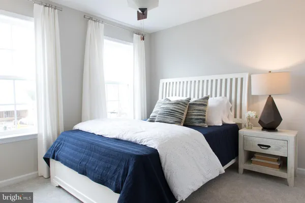 a bedroom with a bed a window and flowerpot