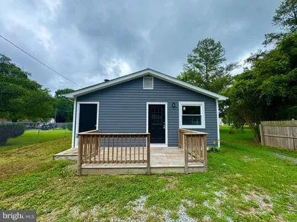 a front view of a house with a yard and fence