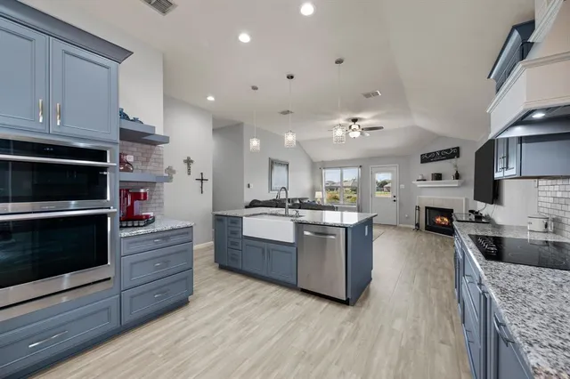 a kitchen with stainless steel appliances granite countertop a stove oven and a refrigerator