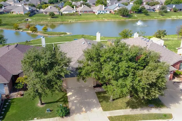 an aerial view of a house with a yard and lake view