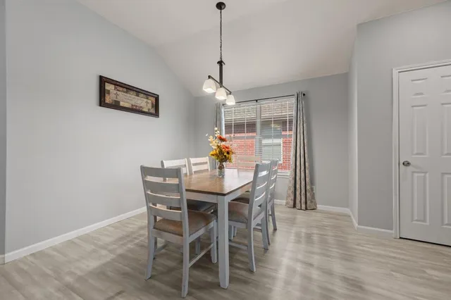 a dining room with furniture window and wooden floor