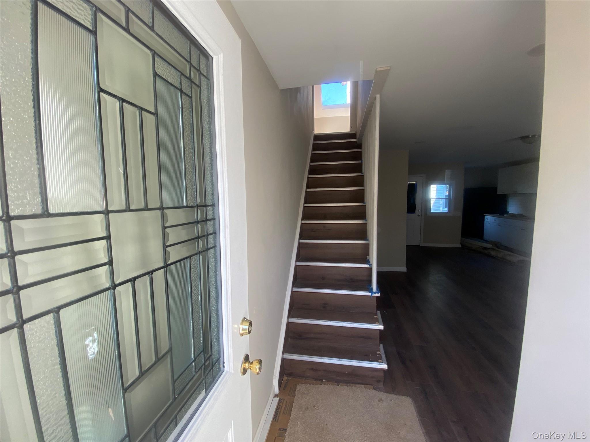 a view of entryway and hall with wooden floor