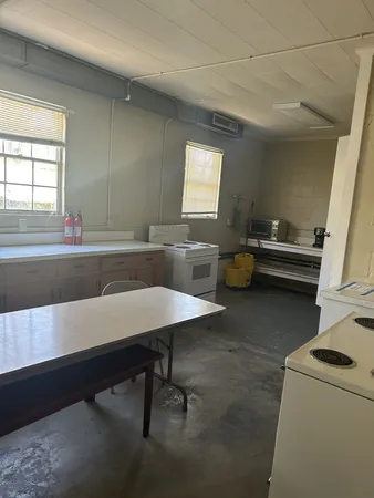 a view of a workspace room with wooden floor and windows