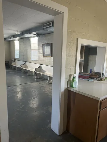 an empty room with a bathroom and windows