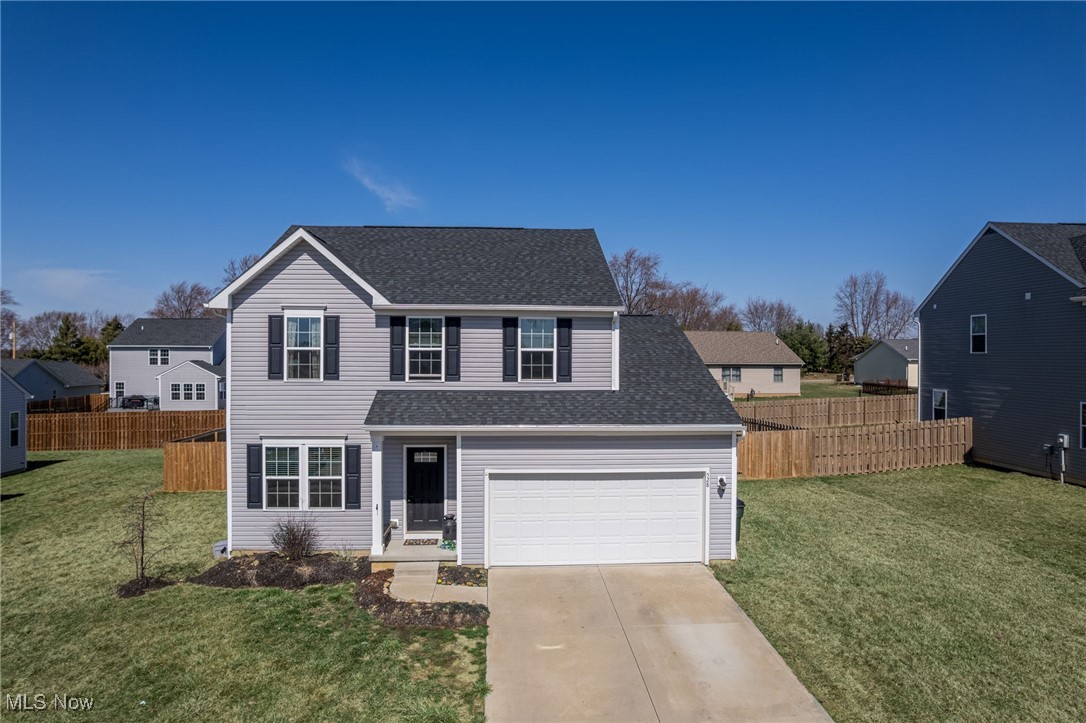528 Oliver Way Rittman, OH 44270 - Photo 2 of 32 Traditional-style house featuring a front lawn, fence, driveway, and a shingled roof
