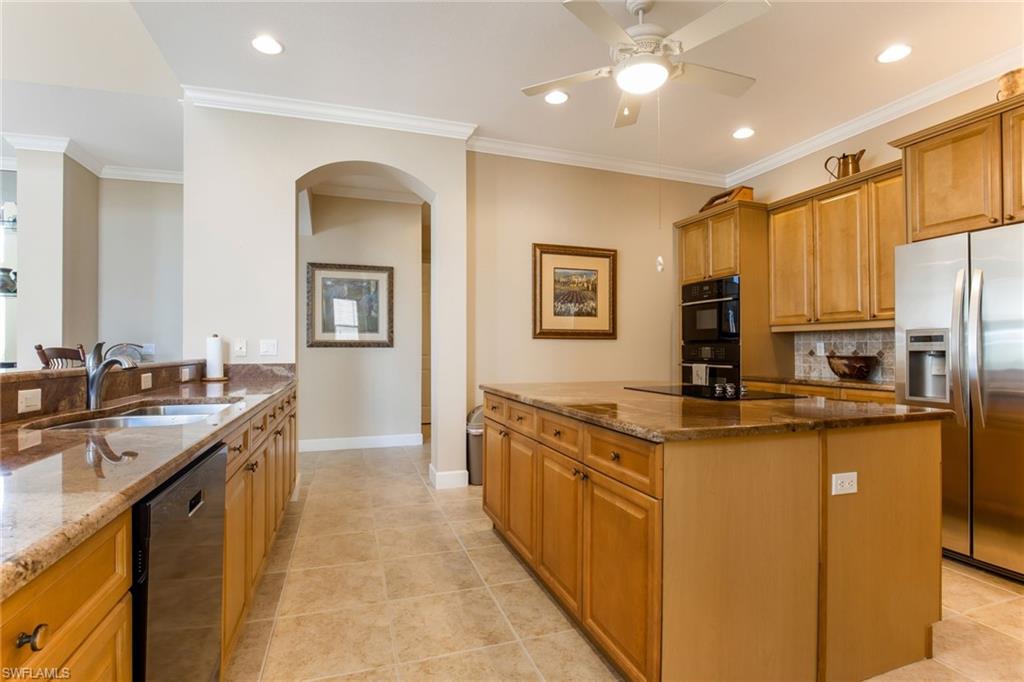 317 Steerforth Court Naples, FL 34110 - Photo 11 of 31 a kitchen with stainless steel appliances granite countertop a sink a stove and a refrigerator