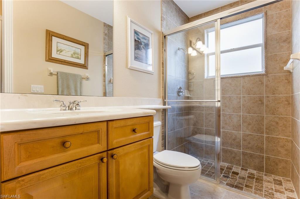 317 Steerforth Court Naples, FL 34110 - Photo 21 of 31 a bathroom with a granite countertop sink toilet and shower