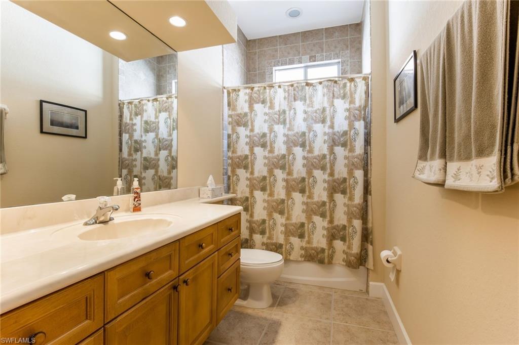 317 Steerforth Court Naples, FL 34110 - Photo 25 of 31 a bathroom with a sink a toilet and shower curtain