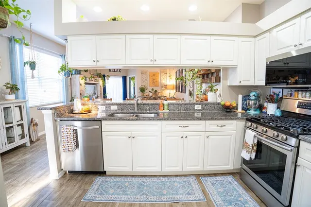 a dining room with stainless steel appliances a dining table chairs and chandelier