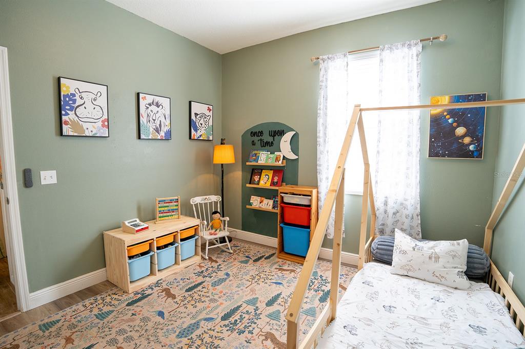 6207 Kiteridge Drive Lithia, FL 33547 - Photo 26 of 39 a bedroom with a bed and wooden floor