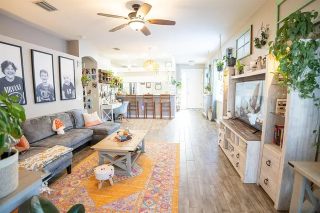 a living room with furniture and a wooden floor