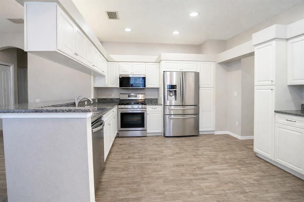 6207 Kiteridge Drive Lithia, FL 33547 - Photo 7 of 25 a kitchen with stainless steel appliances granite countertop a refrigerator a stove and a sink