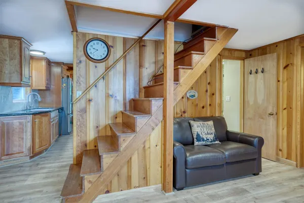 a living room with stairs and wooden floor
