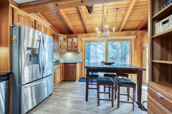 a kitchen with stainless steel appliances granite countertop a refrigerator and wooden cabinets