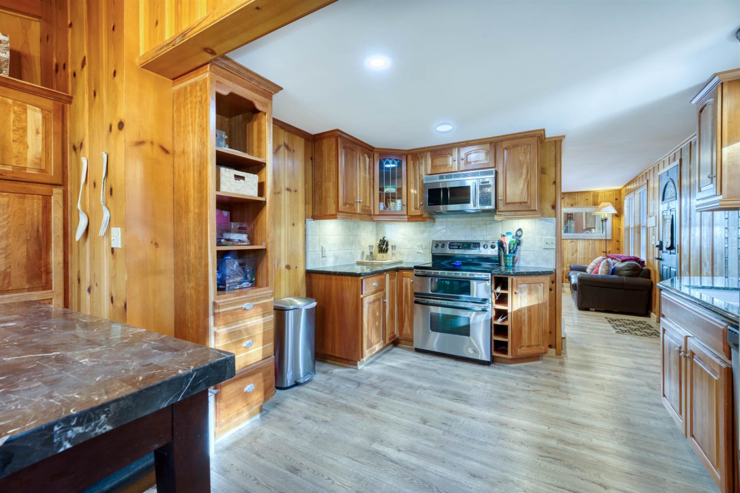 41958 North Aspen Road Shaver Lake, CA 93664 - Photo 21 of 45 a kitchen with stainless steel appliances granite countertop a refrigerator a stove top oven a sink dishwasher and wooden cabinets with wooden floor