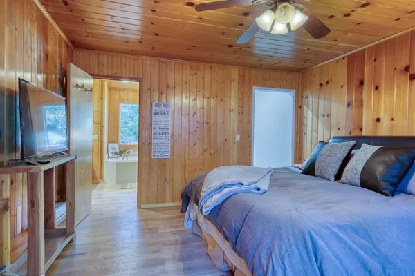 a bedroom with a bed and wooden floor