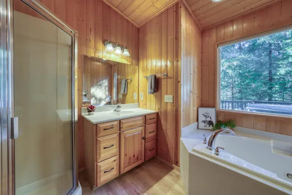 a bathroom with a granite countertop tub sink and mirror