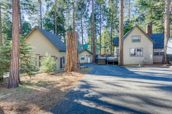 a view of a house with backyard and trees