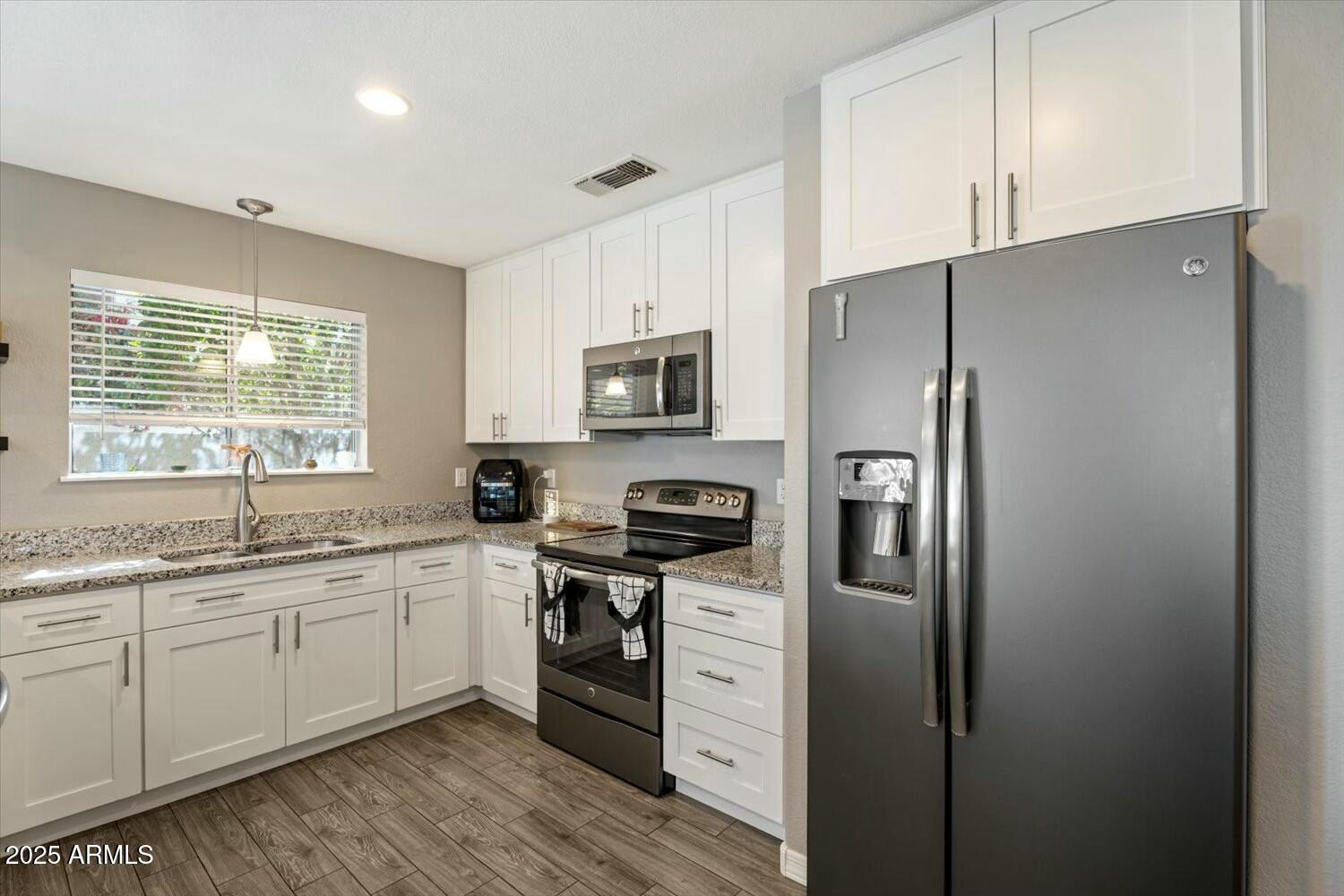 8813 South 51st Street, Unit 3 Phoenix, AZ 85044 - Photo 12 of 28 a kitchen with stainless steel appliances a refrigerator sink and microwave