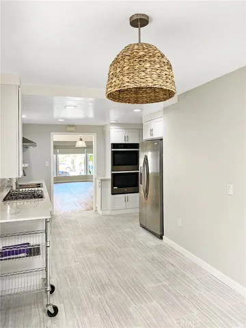 a view of a kitchen with a sink stainless steel appliances and a fireplace
