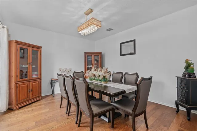 a view of a dining room with furniture wooden floor and chandelier