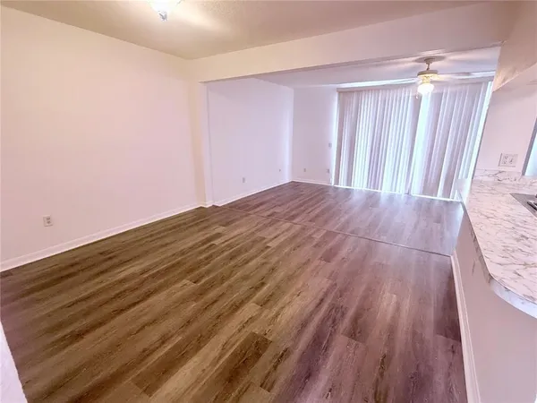 a view of empty room with wooden floor