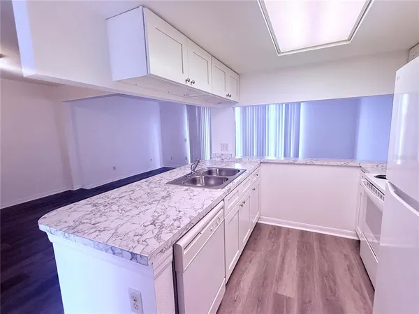 a large kitchen with a sink stove and cabinets