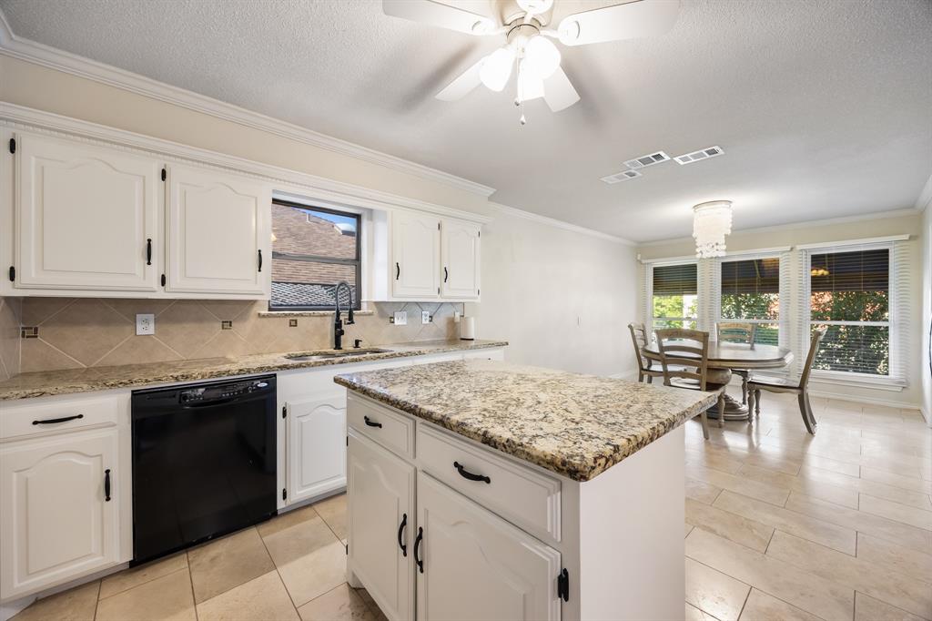 3002 Preston Court Rockwall, TX 75087 - Photo 12 of 39 a kitchen with granite countertop white cabinets and a sink