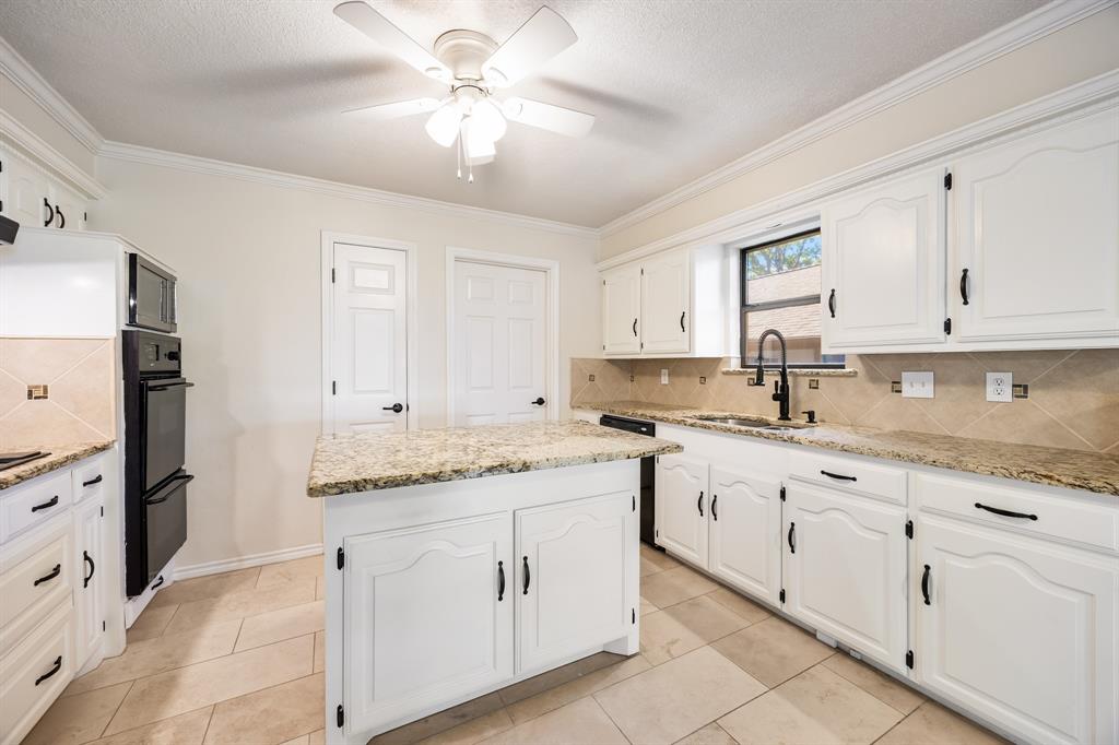 3002 Preston Court Rockwall, TX 75087 - Photo 14 of 39 a kitchen with granite countertop white cabinets white stainless steel appliances with a sink and dishwasher