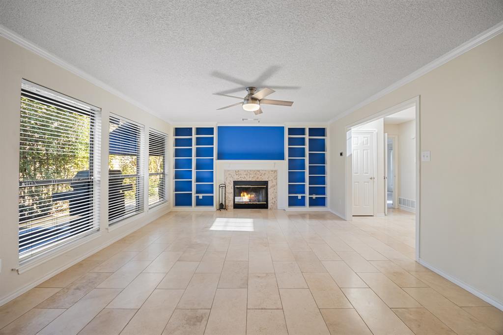 3002 Preston Court Rockwall, TX 75087 - Photo 8 of 39 a view of a livingroom with a fireplace a ceiling fan and windows