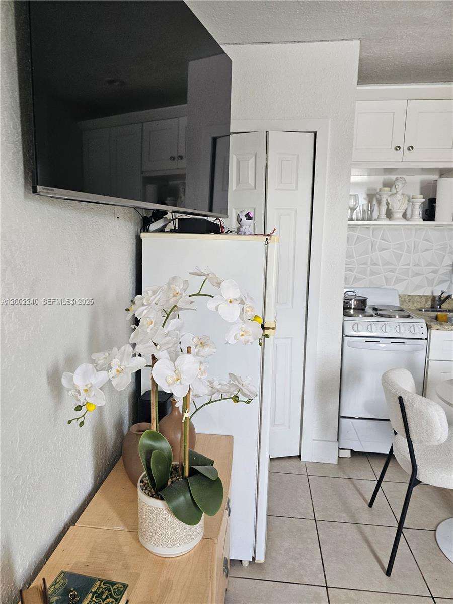 2513 Southwest 10th Street, Unit 5 Miami, FL 33135 - Photo 2 of 5 a kitchen with stainless steel appliances kitchen island granite countertop a refrigerator and a stove top oven