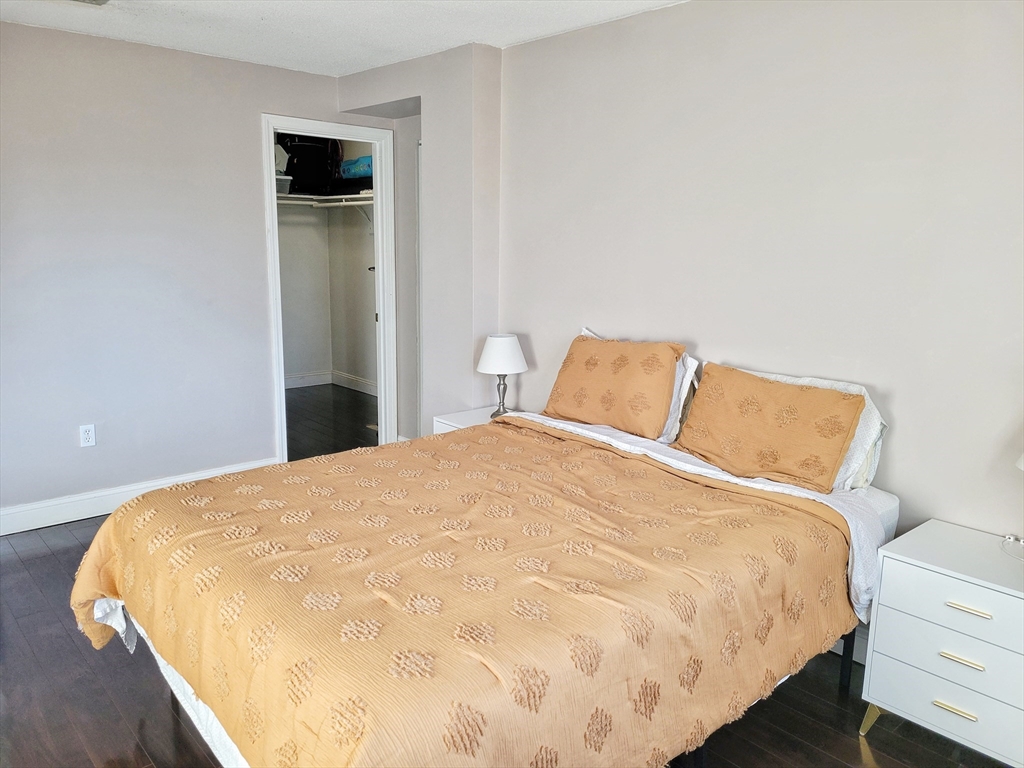 1029 Pleasant Street, Unit 20 Worcester, MA 01602 - Photo 12 of 16 a large bed sitting in a bedroom and wooden floor