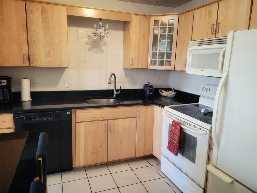 1029 Pleasant Street, Unit 20 Worcester, MA 01602 - Photo 4 of 16 a kitchen with a sink and cabinets