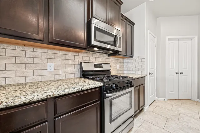 a kitchen with granite countertop cabinets stainless steel appliances and wooden floor
