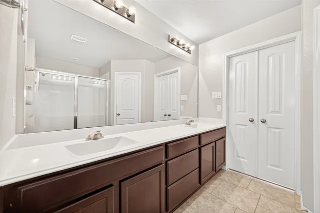 a bathroom with a double vanity sink a mirror and a bathtub